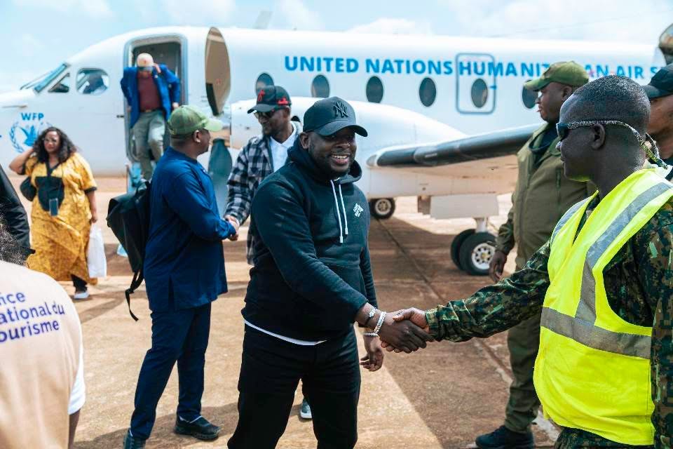 Bakary DIABY accueilli par un officier sur le tarmac, devant l'avion UNHAS