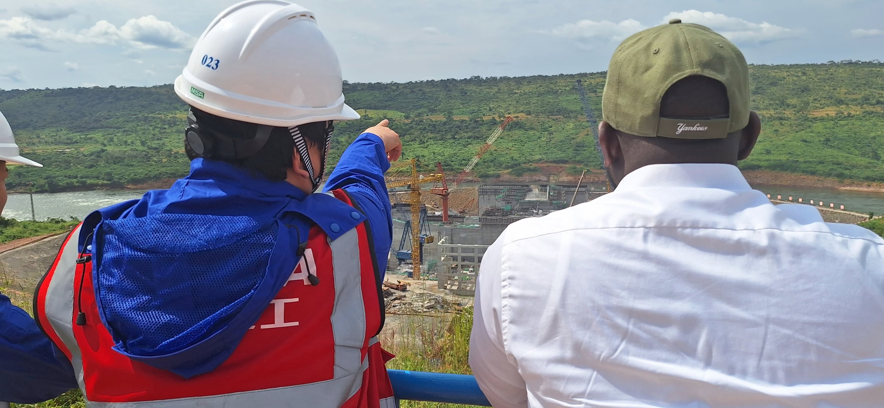 Bakary DIABY et un ingénieur de TBEA observent un barrage hydroélectrique en construction