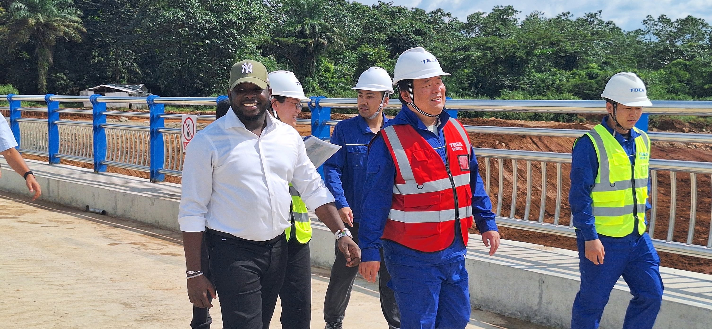 Bakary DIABY traverse un pont achevé avec ses partenaires de TBEA