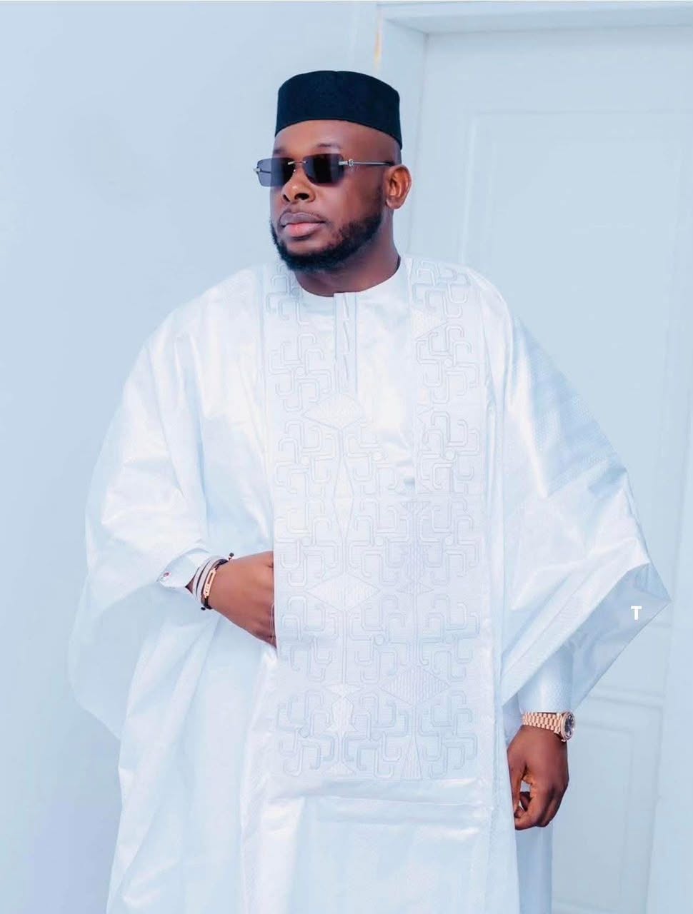 Bakary DIABY en grand boubou blanc brodé, bonnet noir et lunettes de soleil