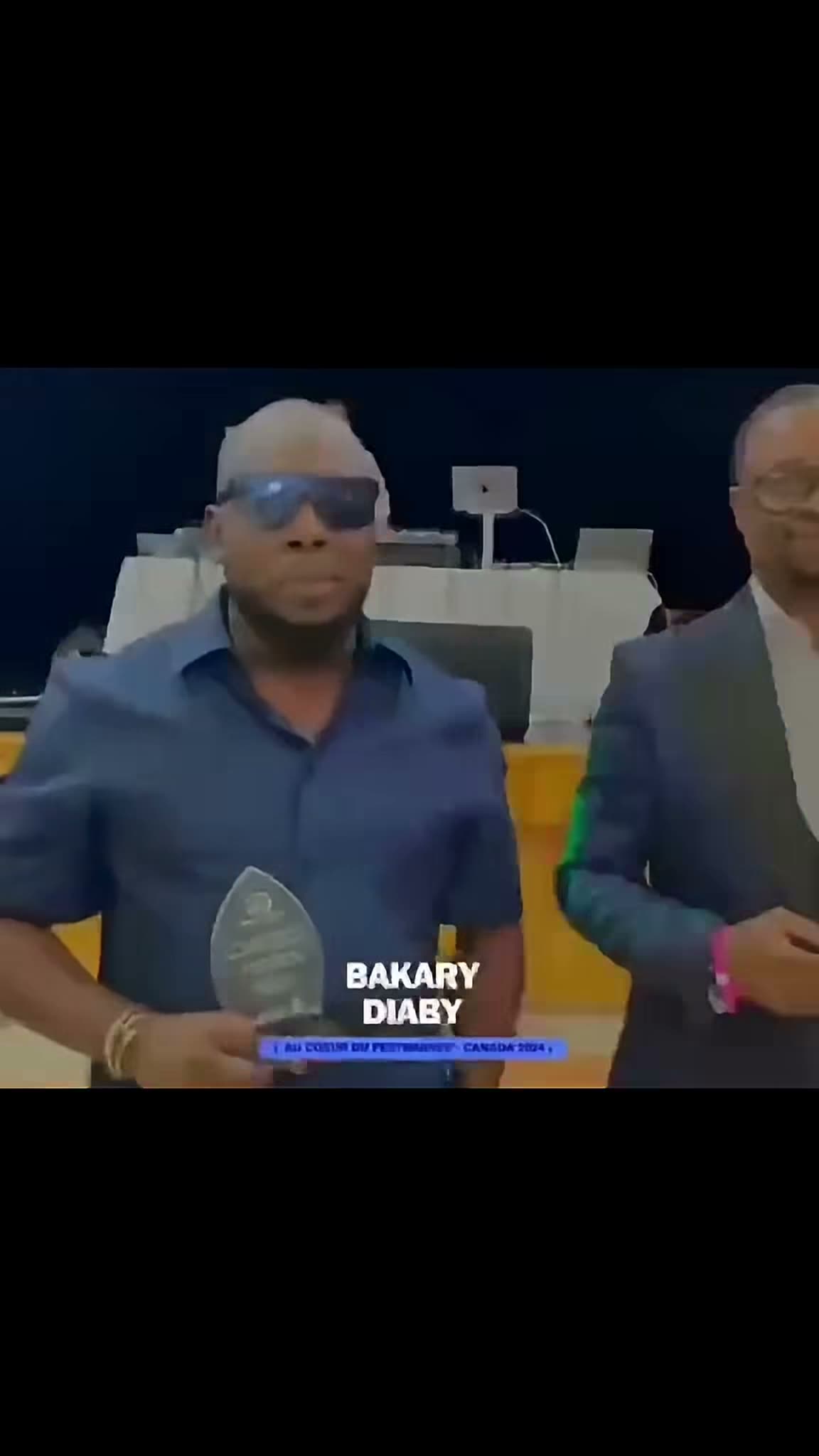 Bakary DIABY tenant un prix lors de l'événement « Au cœur du Festival — Canada 2024 », image tirée du montage hommage